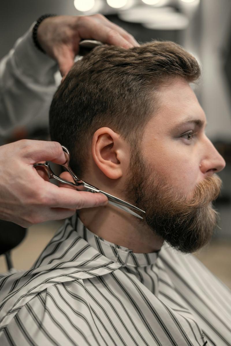 Barber trimmt einen Bart mit der Schere
