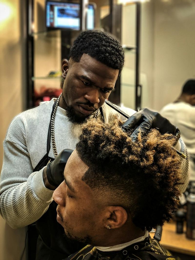 Barber arbeitet an einem Afro Fade