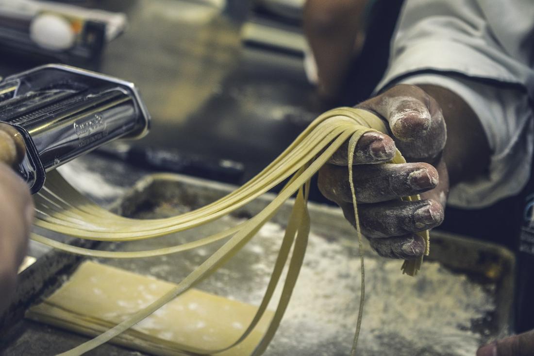 Frische Pasta läuft durch die Pastamaschine