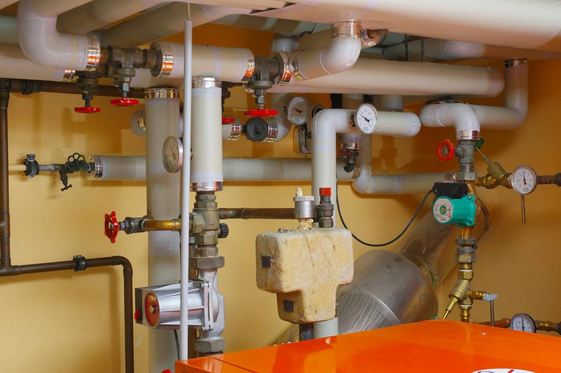 Heizungsraum mit Rohrleitungen, Pumpen und Manometern